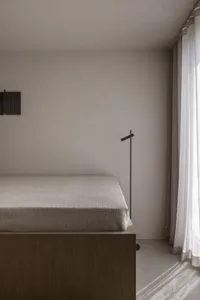 Minimalist bedroom with a bed, curtain, and floor lamp