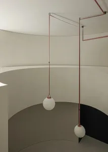 Modern interior staircase featuring a minimalist design with metal railings and white spherical lights.