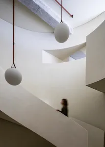 Modern, minimalist staircase with concrete walls and floating light installations.