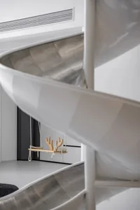 Modern minimalist interior design featuring a white spiral staircase with a metal handrail.