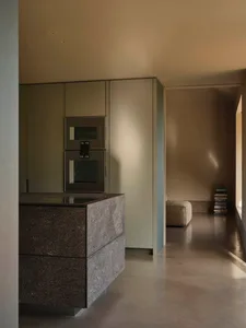 Minimalist kitchen featuring marble countertops and sleek, modern appliances.