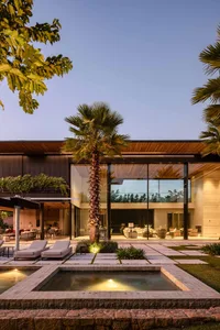 Modern residential exterior featuring a contemporary design with glass, stone, and concrete materials.