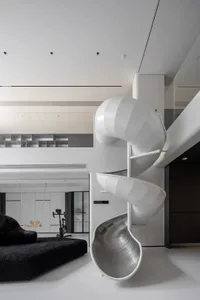 White minimalist living room with a large, modern, white metal slide.