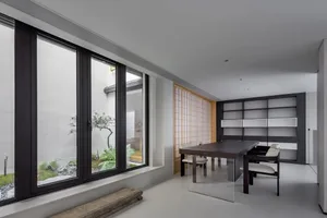 A modern dining room featuring wooden furniture and glass elements, with a minimalist design.