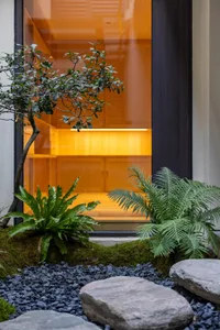 A modern entrance with concrete steps and gravel landscaping.