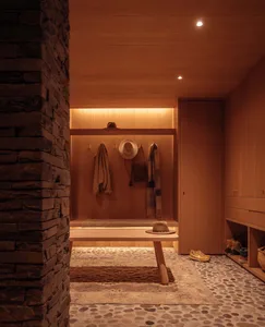 Modern entryway featuring wood storage units, hangers, and bench.