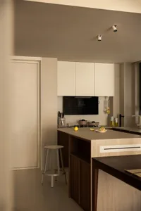 Modern kitchen with wooden cabinets, marble countertops, and stainless steel appliances.