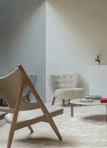 Modern living room featuring wooden furniture and sheepskin upholstery, with a round marble coffee table and a minimalist des