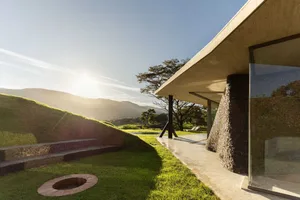 Modern minimalist residential exterior featuring concrete and glass materials.