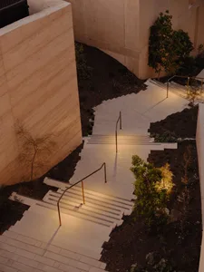Concrete stairs with handrails in an architectural setting.