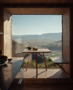 A minimalist kitchen with a window showing a scenic mountain view.