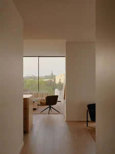 Spacious minimalist living room with wood flooring and leather furniture, showcasing modern design elements and space-saving
