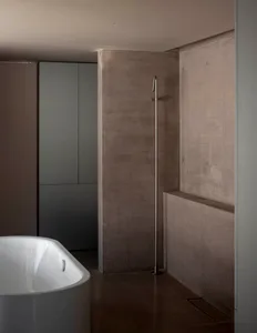 Modern bathroom featuring minimalist design and concrete walls, showcasing contemporary architecture with clean lines and sle