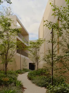 Modern building exterior with concrete walls and green landscaping.