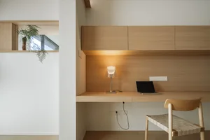 A modern minimalist office setup featuring wooden furniture and a sleek design.