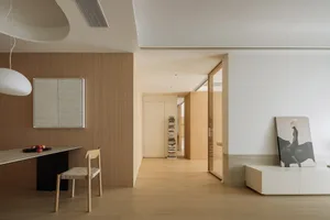 A modern minimalist residential interior featuring wooden furniture and concrete structural elements.