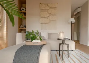 Modern minimalist living room with neutral tones, featuring a sectional sofa, coffee table, and decorative rug.