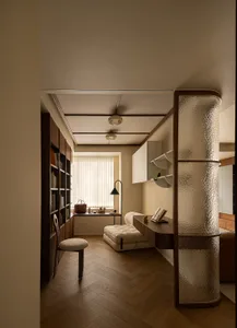 A minimalist living room featuring a wooden floor with a plush beige sofa and a floating desk.