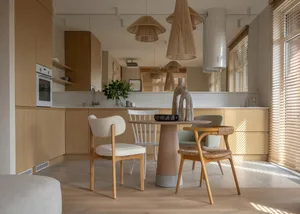 Modern, minimalist residential kitchen featuring wooden cabinets and flooring.