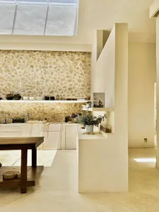 A minimalist residential interior with a concrete floor and stone walls.