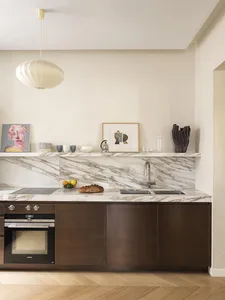 Modern residential kitchen with marble countertops and stainless steel appliances.