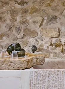 Modern kitchen featuring a stone countertop and brass fixtures.