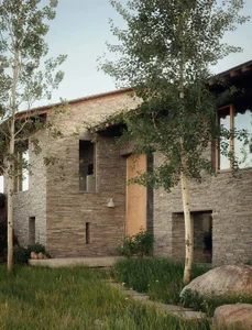 Modern residential building with stone exterior and greenery