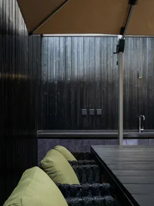 An industrial-style outdoor lounge area featuring metal and wood elements.