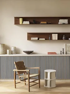 A minimalist living room with wooden furniture, including a woven chair and a low white table.