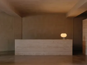 Minimalist reception desk with stone material in a minimalist interior design setting.