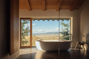 Spacious modern bathroom featuring a concrete bathtub and wood accents with a large window overlooking a scenic landscape.