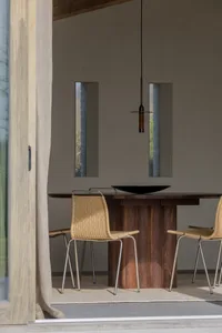 Modern dining room featuring a wooden table and wicker chairs.