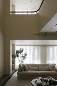 A modern living room featuring a comfortable fabric sofa with a minimalist design, natural light streaming in through large w