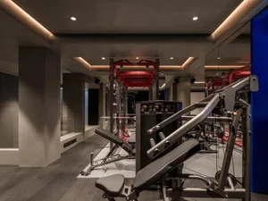Indoor gym interior featuring steel fitness equipment and mirrors.