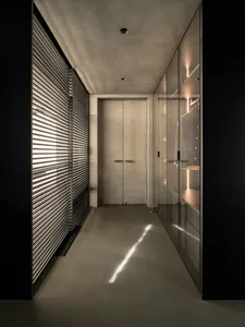 Modern closet with glass cabinets and concrete floor.