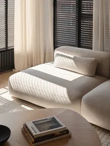 Modern living room with a cushion, curtains, and a wooden coffee table.