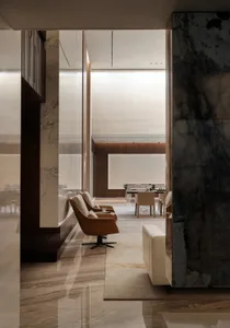 A modern living room with marble flooring and leather furniture.