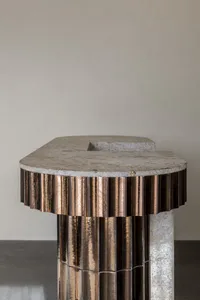 Close-up of a modern metal table with a stone top.