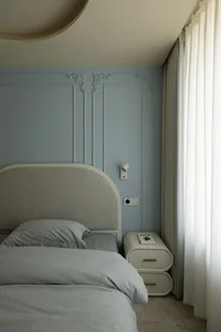 A modern minimalist bedroom with white bedding and plush fabric elements.