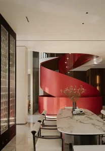 Modern residential staircase with sleek, curved red metal railings and lighting.