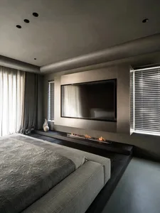 A modern bedroom featuring metallic elements and a large flat-screen television.