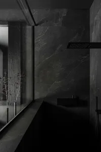 A modern bathroom with dark stone walls and minimalist design features.