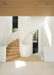 A modern interior design featuring a white staircase with wooden steps and white walls.
