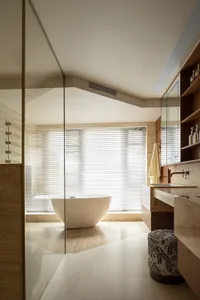 Modern minimalist bathroom featuring white marble walls and a freestanding bathtub