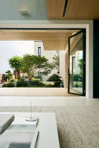 A modern residential interior featuring a wooden floor and concrete walls.