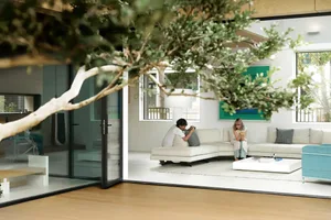 A modern white living room with a white couch and a white coffee table.