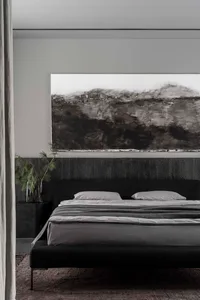Modern bedroom with black textured walls, minimalist furniture, and abstract black-and-white artwork.