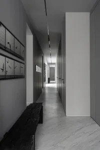 A minimalist corridor with concrete walls and flooring.