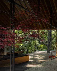 The image showcases a minimalist residential space featuring elements like wood, glass, and metal.