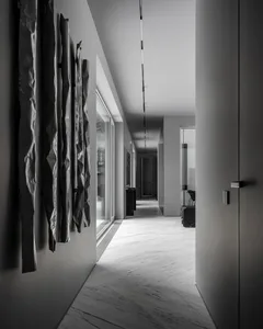 Modern industrial suite hallway featuring metallic ribbons hanging from the ceiling and linear lighting fixtures.